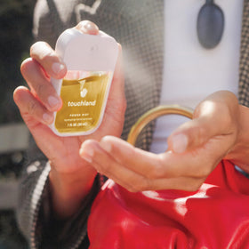 Touchland sprays inside a handbag illustrating everyday carry convenience