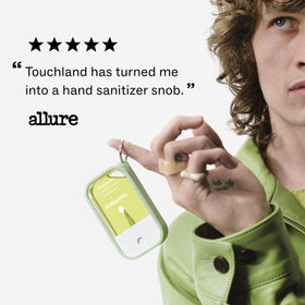 Touchland hand-in-use spritzed to show easy application and on-the-go convenience