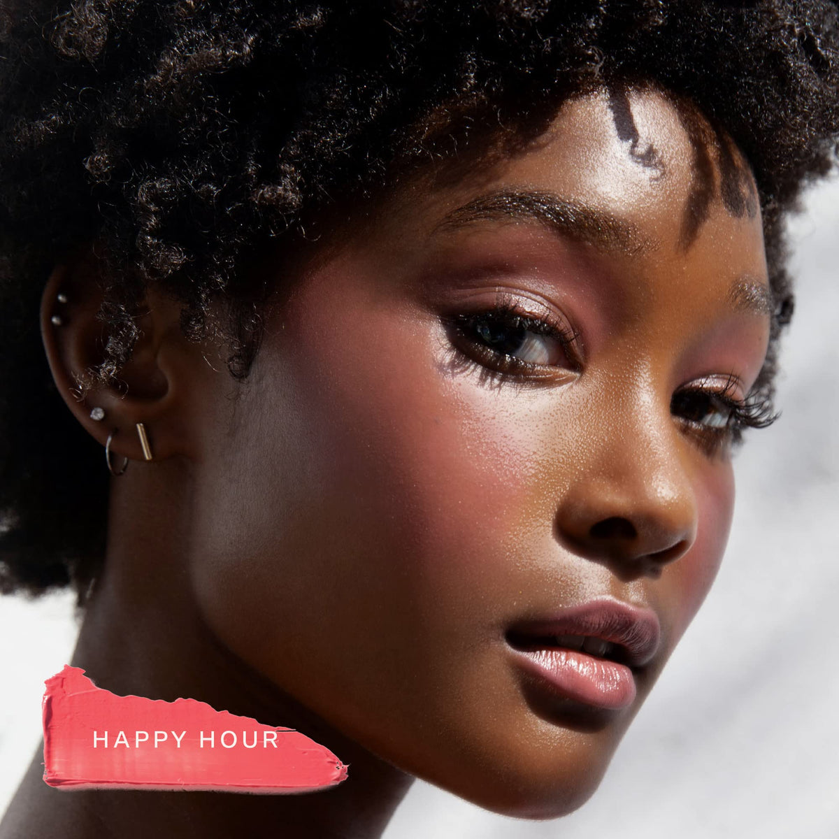 Tower 28 lip and cheek tint in a beach setting conveying sun-kissed glow
