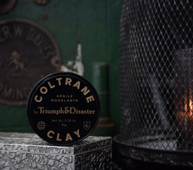 TRIUMPH & DISASTER label close-up revealing smoky-earth scent notes and premium branding