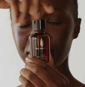 True Botanicals bottle on vanity in lifestyle scene conveying calm, radiant skin