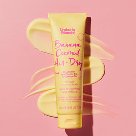 Umberto Giannini cream in hand being applied to damp hair for hydration
