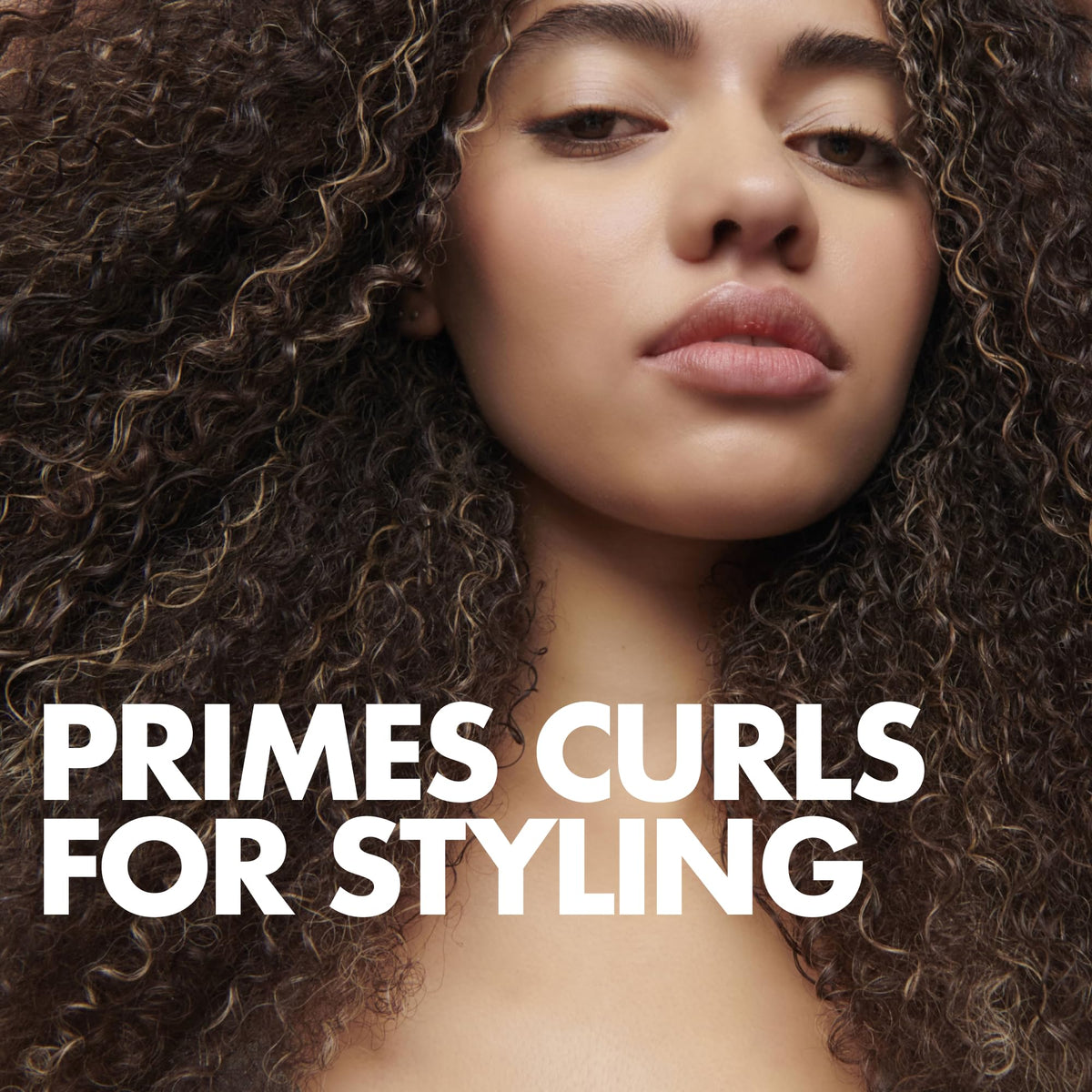 Applying Umberto Giannini curl jelly to damp hair with hands for controlled styling
