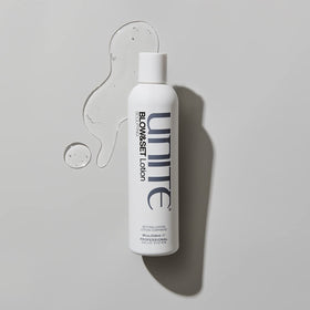 UNITE bottle held in hand for scale to show 8 fl oz size and portability