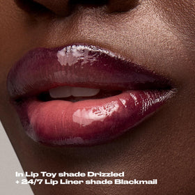Urban Decay lip oil next to coin showing compact travel-friendly size