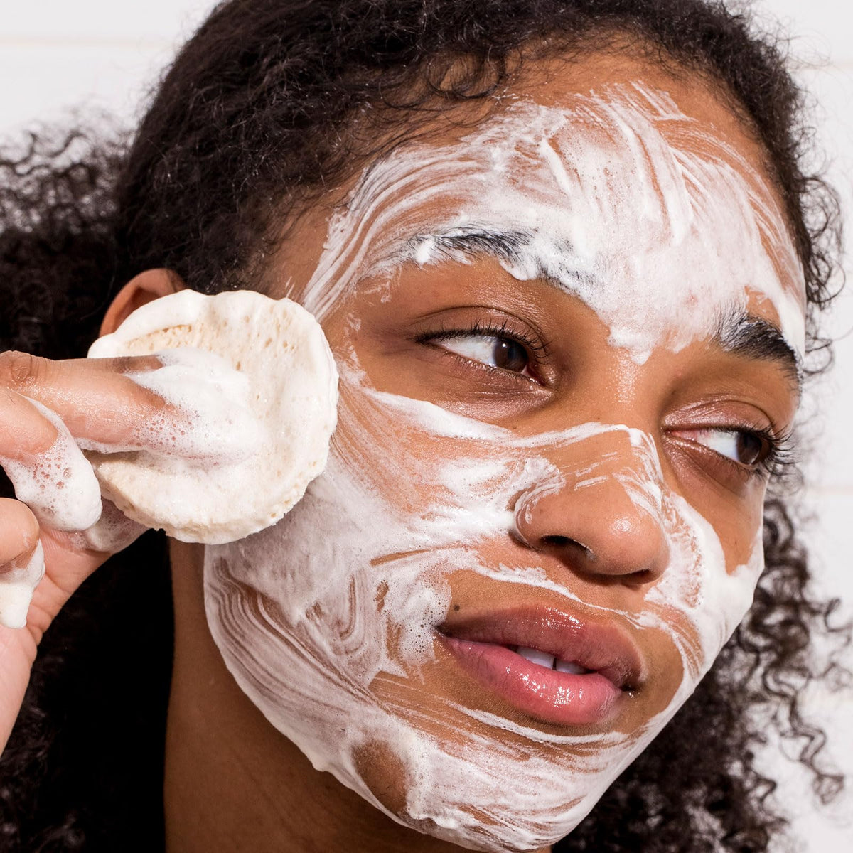 Urban Skin Rx cleansing bar held in hand to show size and portability for travel-friendly use