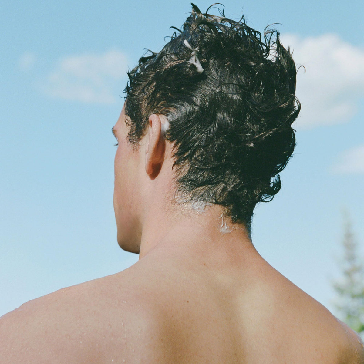 Ursa Major shampoo being dispensed in shower showing easy application benefit