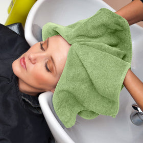 Utopia Towels next to a hand to illustrate size and practical scale