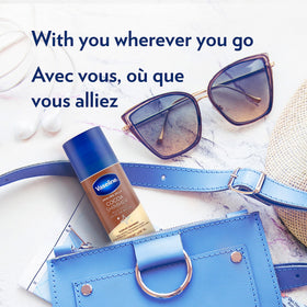 Vaseline cocoa shimmer stick in hand showing compact 1.4 oz travel-friendly size