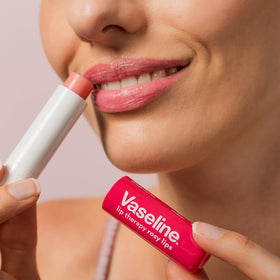 Vaseline rosy lips on desk amid daily items showing always-available hydration