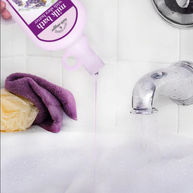 Village Naturals Bath Shoppe bottle held in hand showing real size and easy-pour benefit