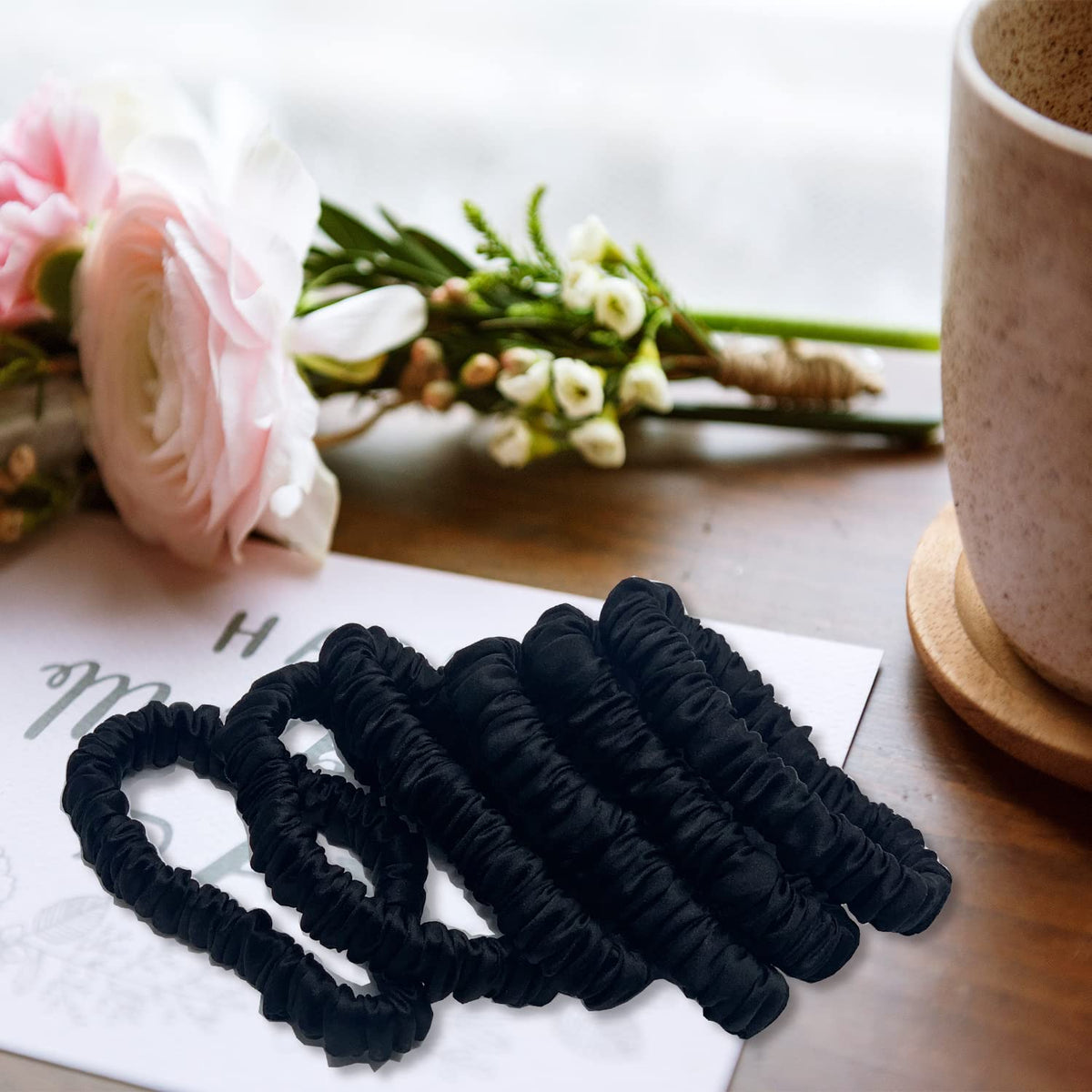 VLOMOT scrunchie next to coin showing compact size and travel readiness