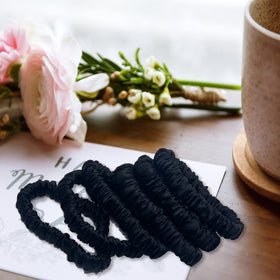 VLOMOT scrunchie next to coin showing compact size and travel readiness