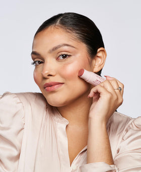 Wander Beauty stick held in hand to show scale and travel-friendly size for on-the-go touch-ups