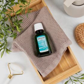 Weleda oil applied to scalp by fingers, demonstrates targeted nourishment