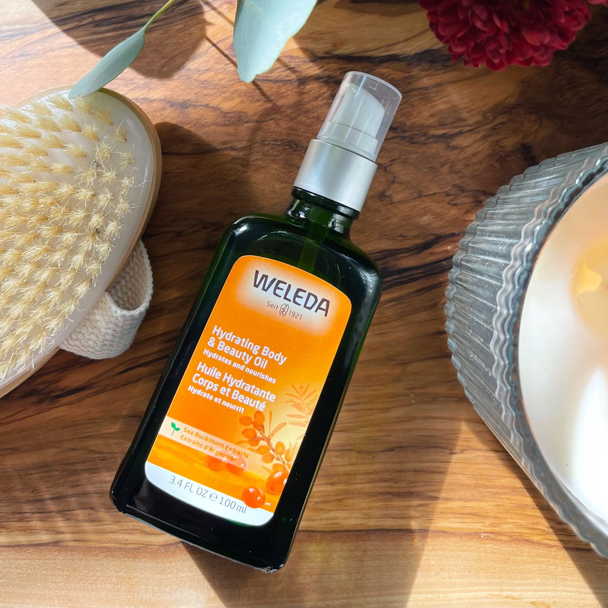 Weleda applying oil on arm showing soft, hydrated skin result