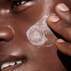 Well People cleanser held in hand to show size and travel-friendly scale benefit