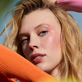 Well People balm applied on lips showing sheer peach tint and natural look benefit