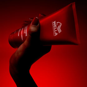 Wella Professionals tube held in hand to show compact travel size