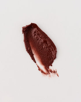 Winky Lux balm on a coffee table with cup showing espresso-vanilla scent enjoyment benefit