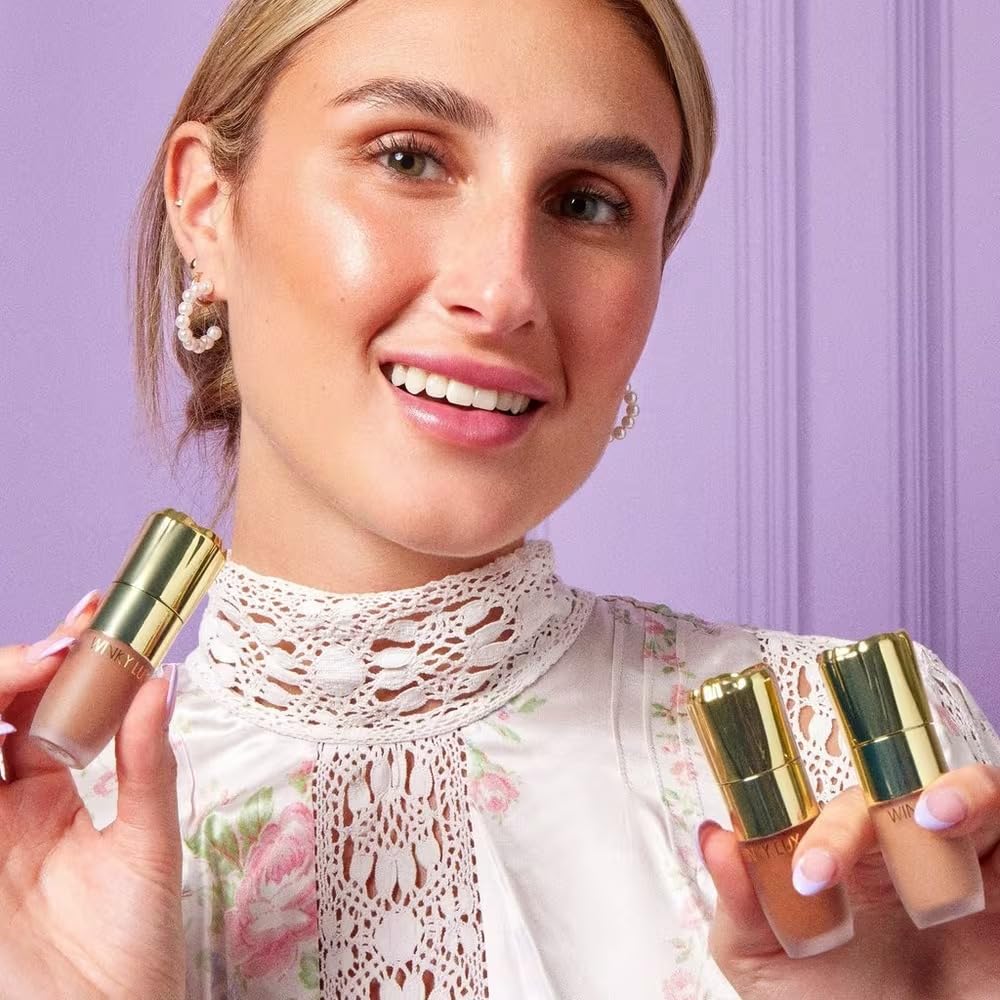 Winky Lux tube held in hand to show true size and travel-friendly convenience
