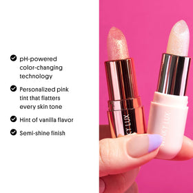 Winky Lux balm next to a coin illustrating compact size and travel-friendly convenience