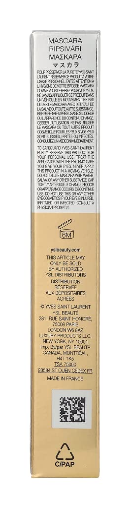 Woman applying Yves Saint Laurent mascara in a vanity setting showcasing defined, fuller-looking lashes